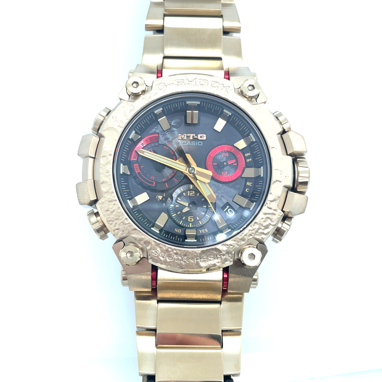 CASIO G-SHOCK WATCH WITH ROUND BLACK DIAL WITH RED ACCENTS; GOLD TONE BRACELET
